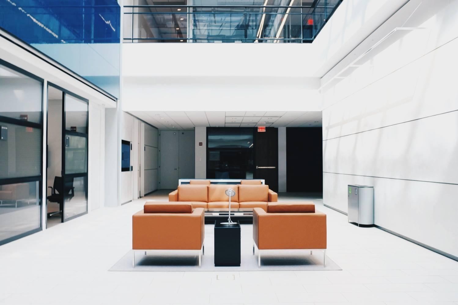 Brown sofas in a brightly lit white office space.